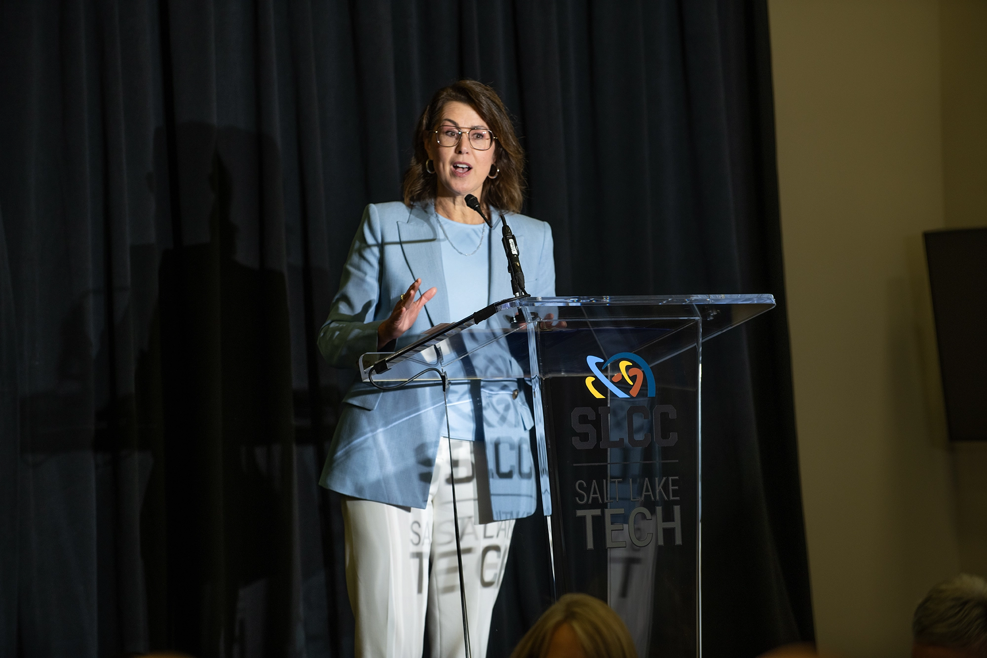 Lieutenant Governor Deidre Henderson addresses the crowd from behind the same translucent lectern. She’s speaking animatedly about the College’s impact and future with President Peterson as a leader. 