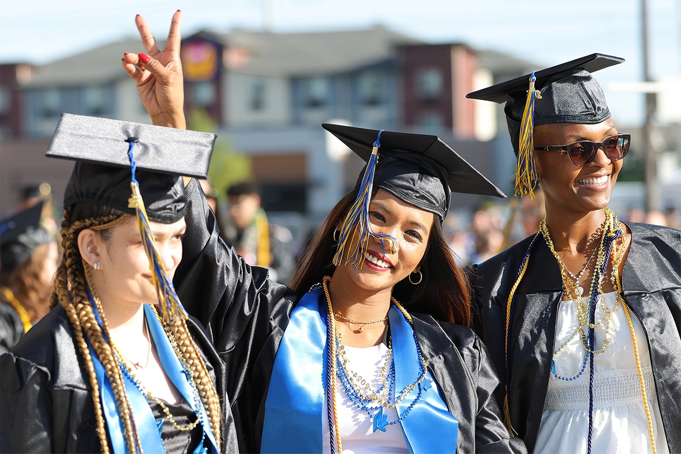 Three female students each wearing graduation attire.
