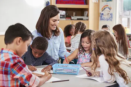 a group of children in class raising their hands